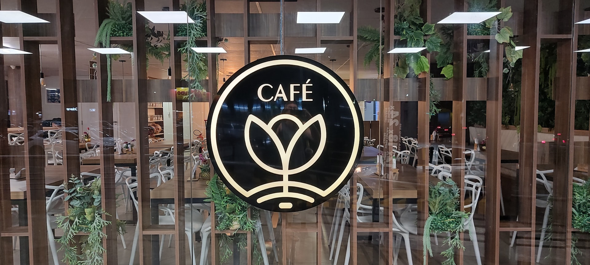 a cafe sign hanging from the side of a building